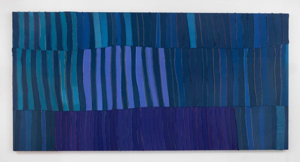 A canvas features a geometric pattern in blue that is actually dozens of durags that have been carefully stitched together.