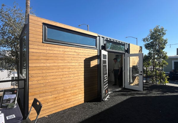 A shipping crate home paneled is shown on a sunny day in Altadena