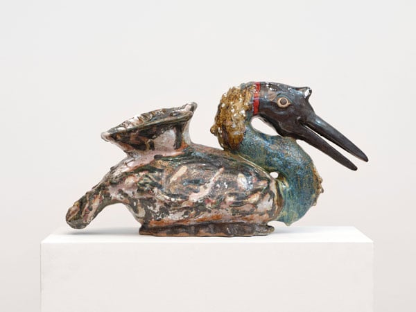 A side view of a colorful ceramic vessel by Karin Gulbran takes the form of a resting goose with its beak partly open