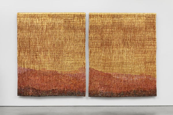 A pair of weavings in golden tones, by Olga de Amaral, show the subtle outline of mountains