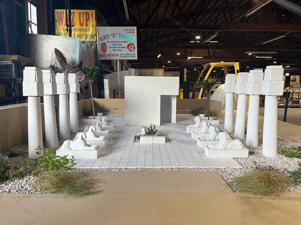 A maquette of an Egyptian-style park space sits on a toabletop in an warehouse studio.