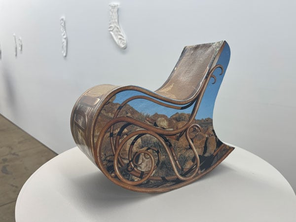 A sculpture by Ry Rocklen of a rocking chair is made up of photographs of rocking chairs, obscuring sculptural elements within.