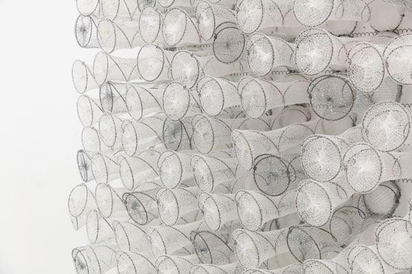 A sculpture by Bronwyn Katz shows dozens of looping wire coils covered in gauzy white mesh, resembling some strange underwater plant.