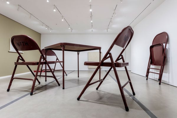 A massively sized folding table and chairs by Robert Therrien occupy a museum gallery.
