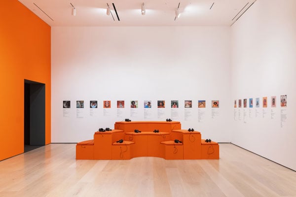 An orange staggered seating area features headphones to listen to Coltrane albums