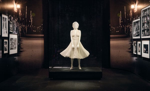 An installation view of an exhibition about Marilyn Monroe shows a mannequin, styled to resemble Monroe, in the white dress she wore in a famous image showing her standing on a subway grate.