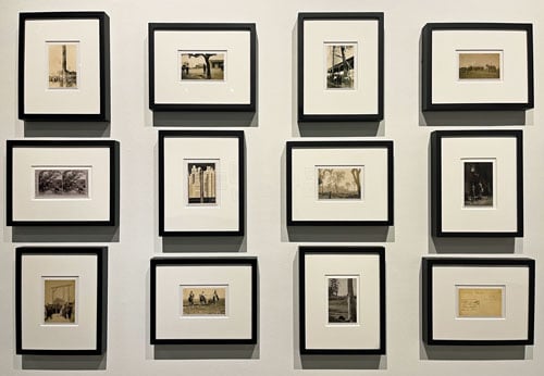 A photo of a gallery wall shows 12 small framed images rendered in sepia tones.