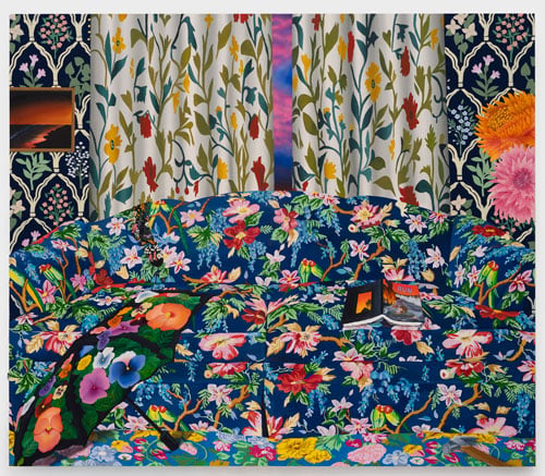 A painting shows an interior bursting with floral patters, including a couch with blue florals and a curtain with white florals. On patterned wallpaper hangs a small painting showing a beach in toxic light.