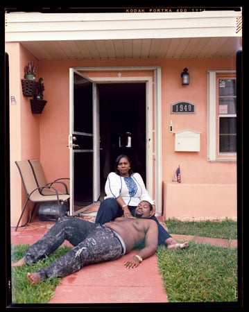 A photograph by Jon Henry shows a mother supporting her son's body in the style of a pietà on the front porch of a house.