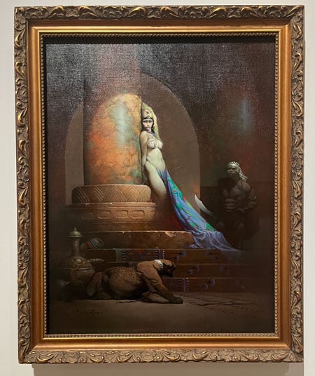 A painting by Frank Frazetta shows a woman in harem garb leaning against a column. Behind her is a burly guard in ancient Egyptian costume and below her is a large toothy feline.