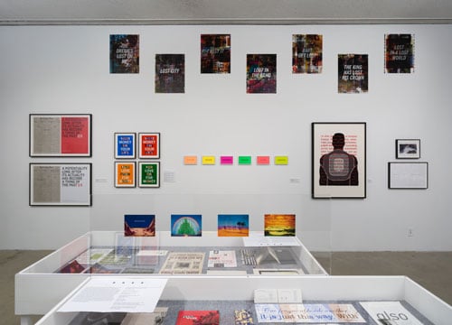 An installation view of Susan Silton's survey at the LA Municipal Art Gallery shows various works of text and image on a gallery wall.