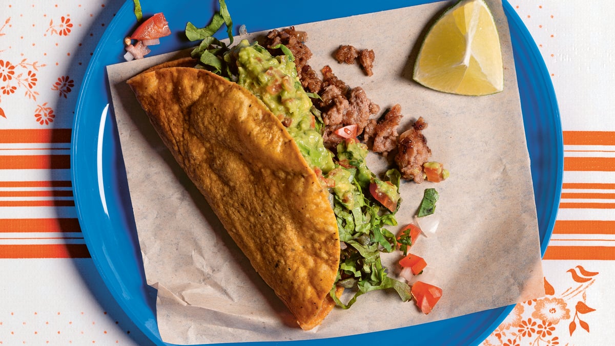 Hardshell taco filled with meat and guacamole. Photo by Araceli Pax