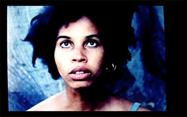 A film still shows a close-up on Black actor Pamela Jones looking upwards