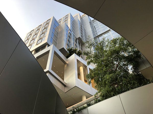 The residential tower of Frank Gehry's Grand LA complex is seen upwards between curving walkways.