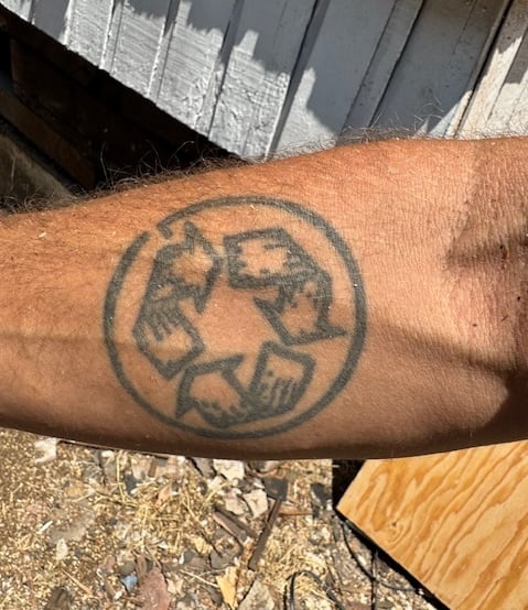 Jacques Laramees tattoo of recycle symbol