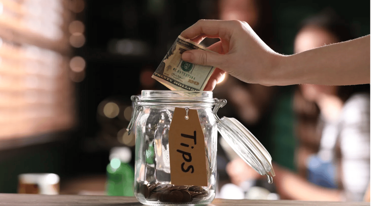 The tip jar looks quaint in light of a glaring tablet with a suggested percentage to leave. But in this age of technology, who should we tip and how much? Photo courtesy of Shutterstock.