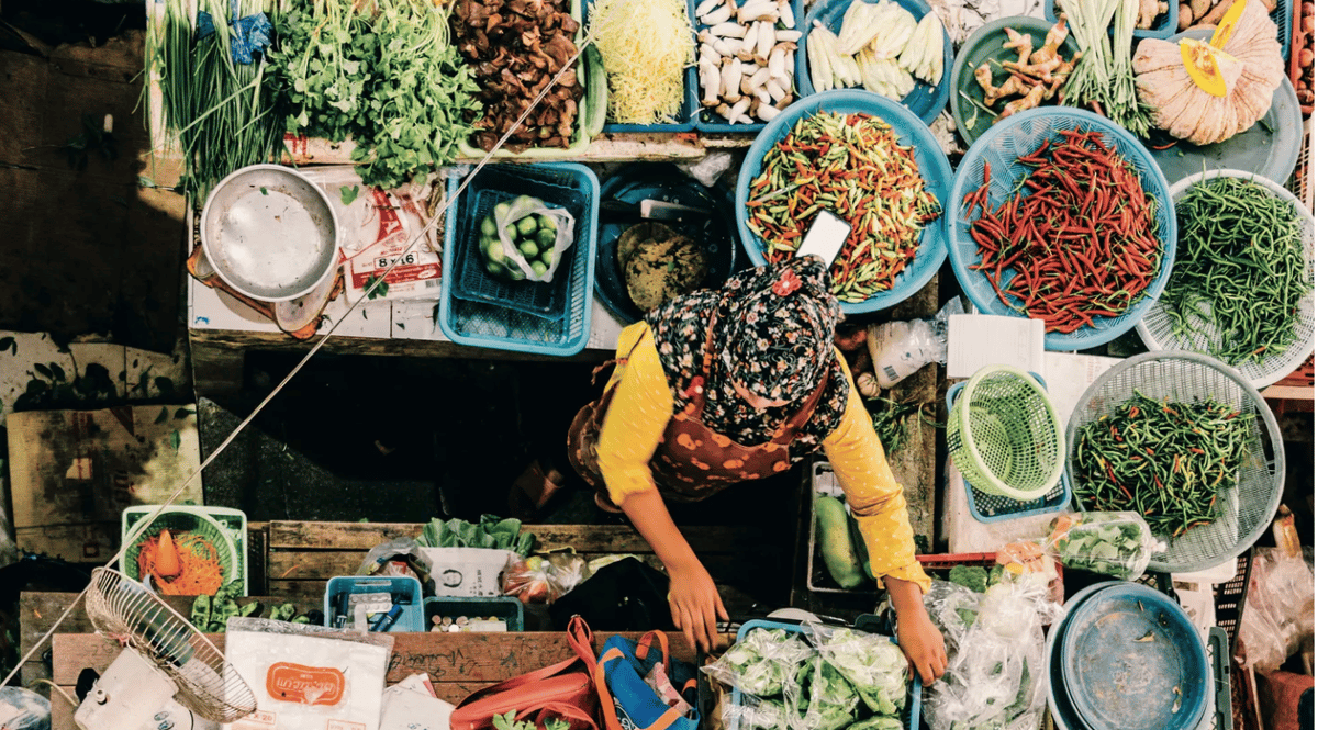 A woman sells vegetables in Southern Thailand. Photo by Austin Bush.