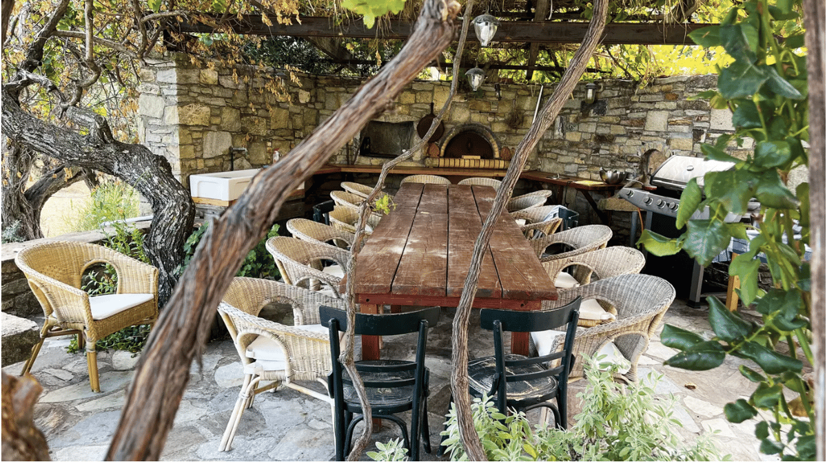 The table in Daine Kochilas' garden in Greece, where she hosts cooking classes. Photo credit is Vasilis Stenos