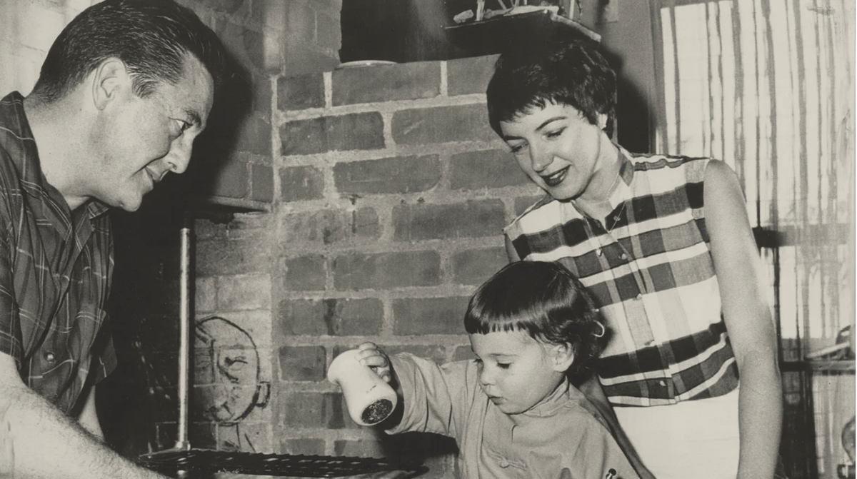 Flanked by her parents, actor Edward Binns and journalist Marcia Legere Binns, the author salts a steak in a photo for TV Guide. Photo courtesy of Brigit Binns.