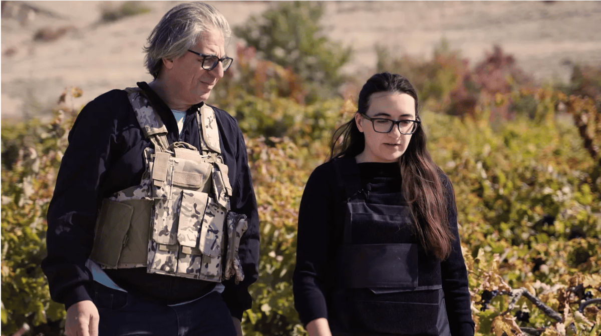 Vahe Keushguerian (left) and his daughter, Aimee, wear bulletproof vests as they harvest grapes on the border of Armenia and Azerbaijan. Photo courtesy of Somm TV.