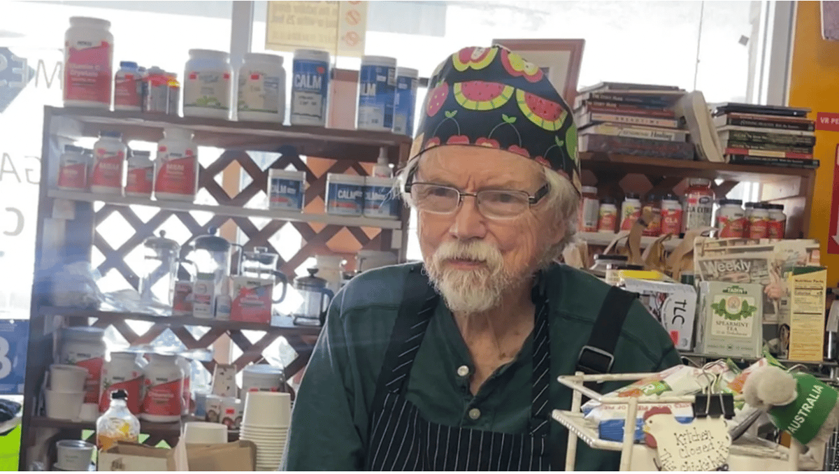 John Hopkins stands behind the register of O Happy Days, an Altadena market and vegan cafe that perished in the Eaton Fire. Photo by Vanessa Anderson.