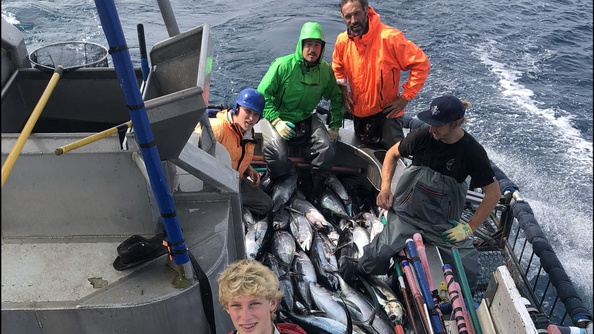 Scott Hawkins photographs his crew, including his sons Wyatt (left, blue helmet) and Colton (front, red jacket) with dozens of albacore tuna they caught in minutes. Photo by Scott Hawkins.