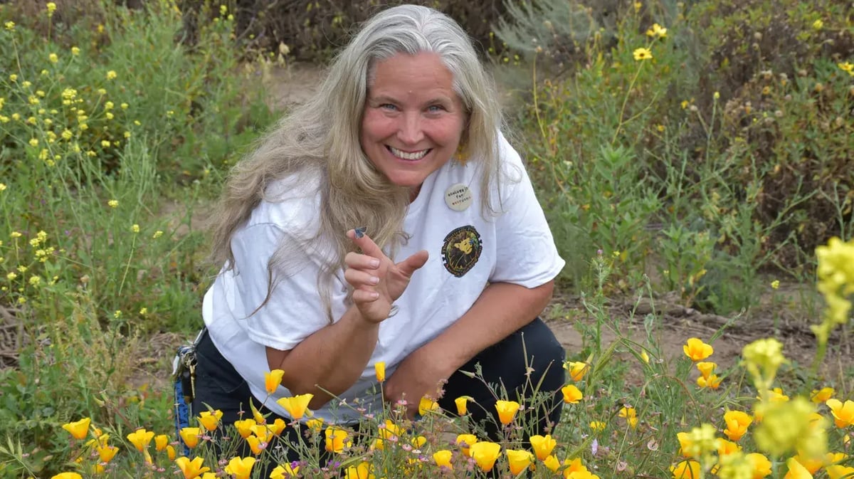 Jana Johnson poses with a Palos Verdes blue butterfly during a spring 2024 release at a Rolling Hills Estates reserve. Photo by Susan Valot.