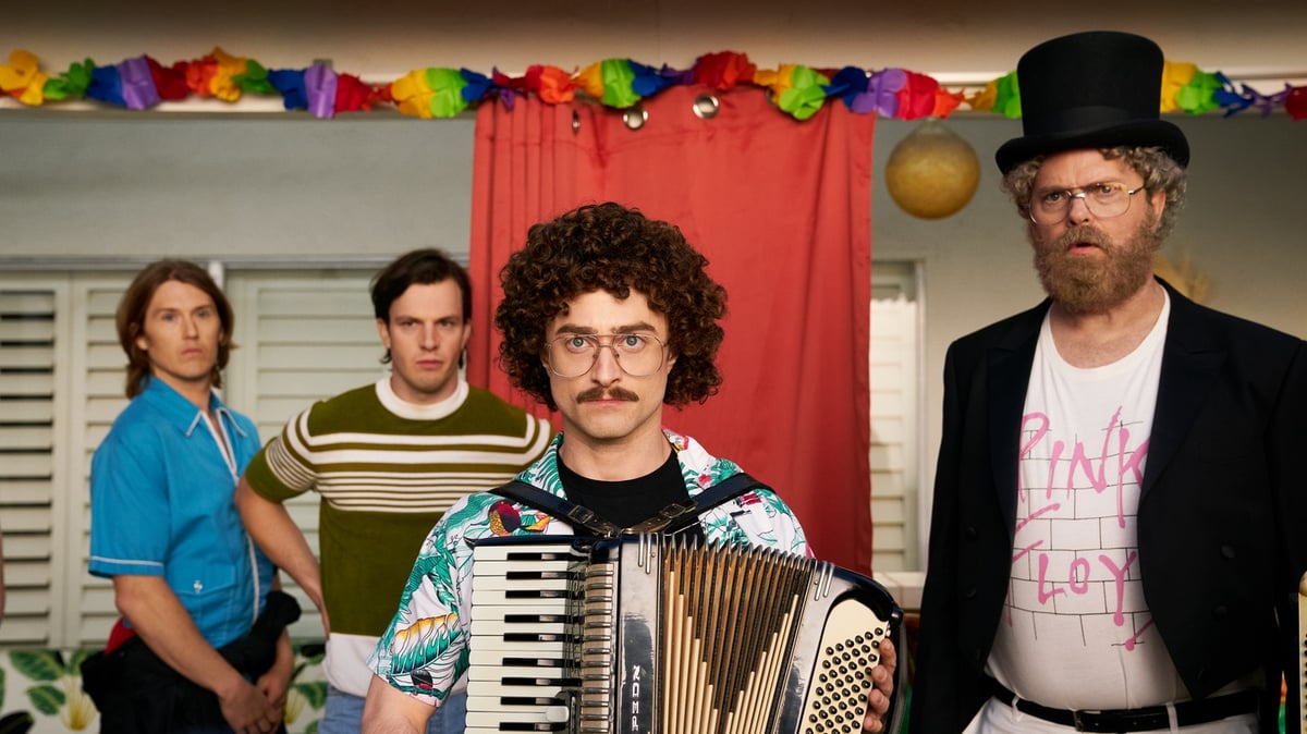 Daniel Radcliffe (center, front) plays Weird Al, and Rainn Wilson (far right) plays Dr. Demento in “Weird: The Al Yankovic Story.” Photo courtesy of The Roku Channel.