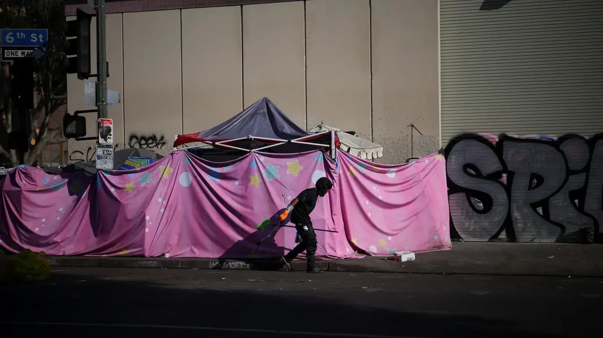 A man walks by a homeless tent encampment in Skid Row, Los Angeles, California, U.S., December 9, 2024. Photo by REUTERS/Daniel Cole.